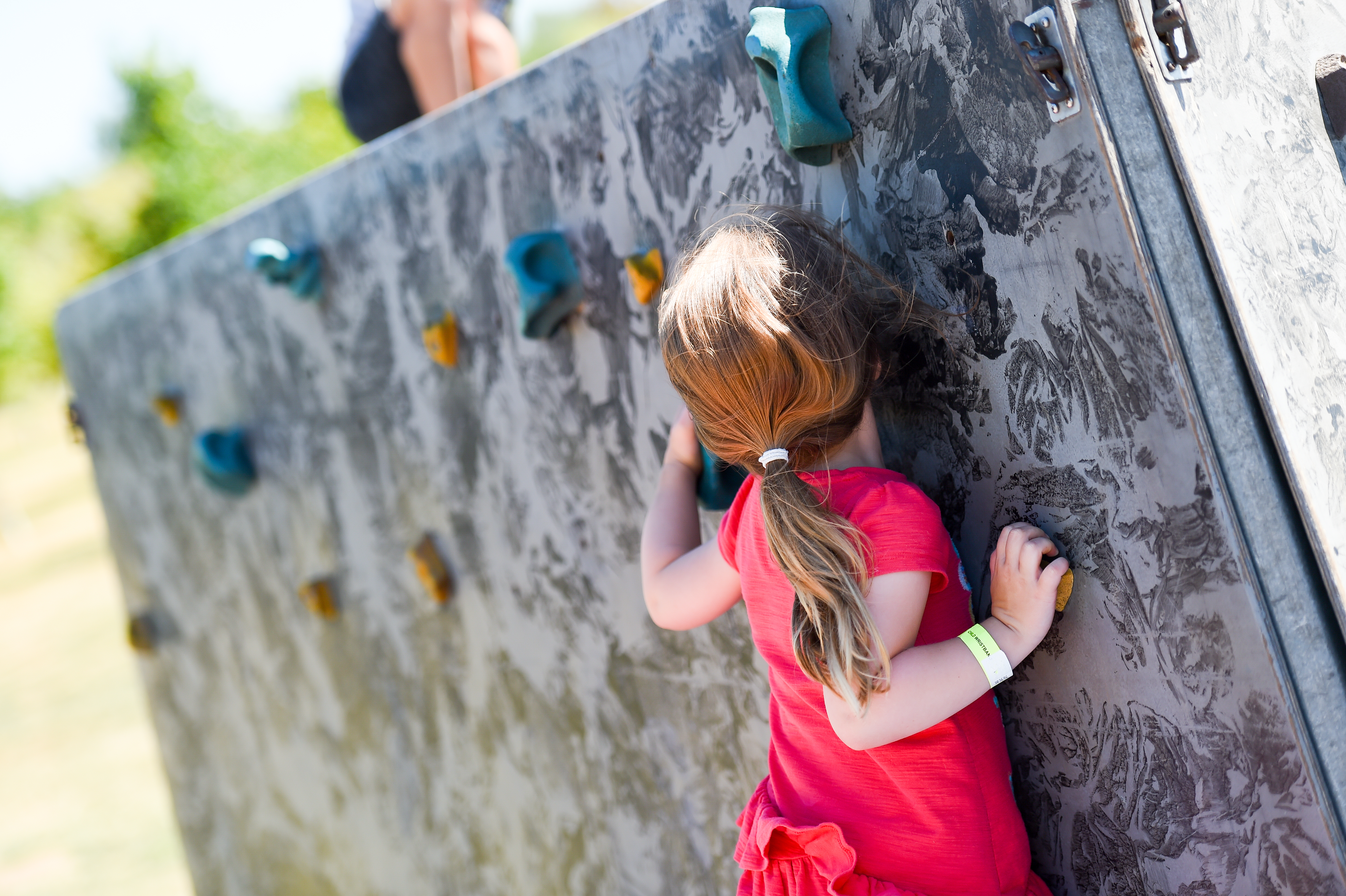A young girl climbing on a climbing wall on Armed Forces Day in 2018