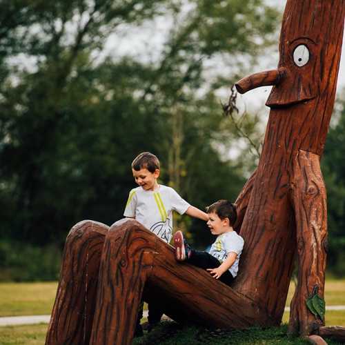 Children sitting on Stick Man at the Arboretum