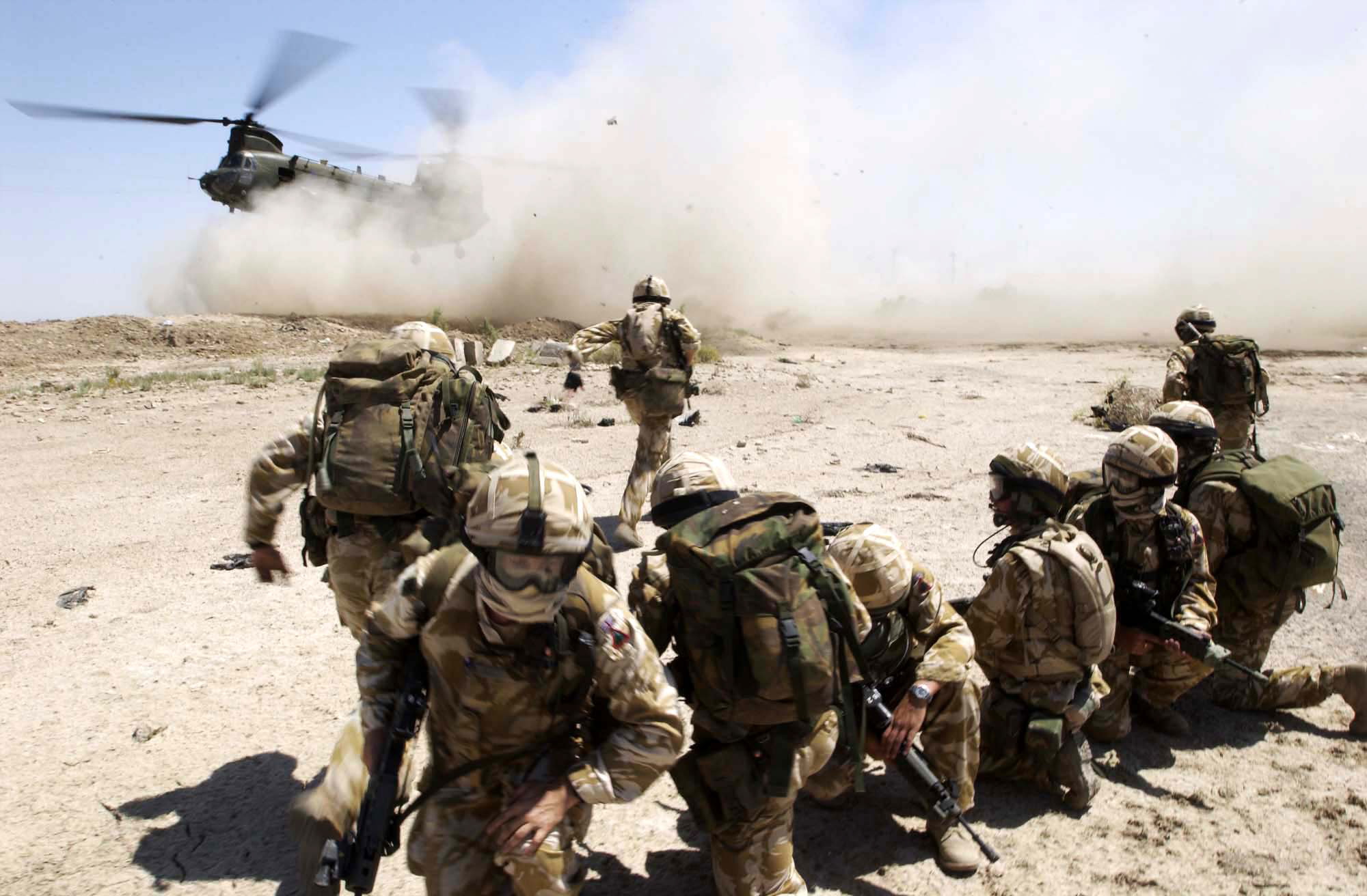 Image of soliders in Iraq running to meet a chinook helicopter