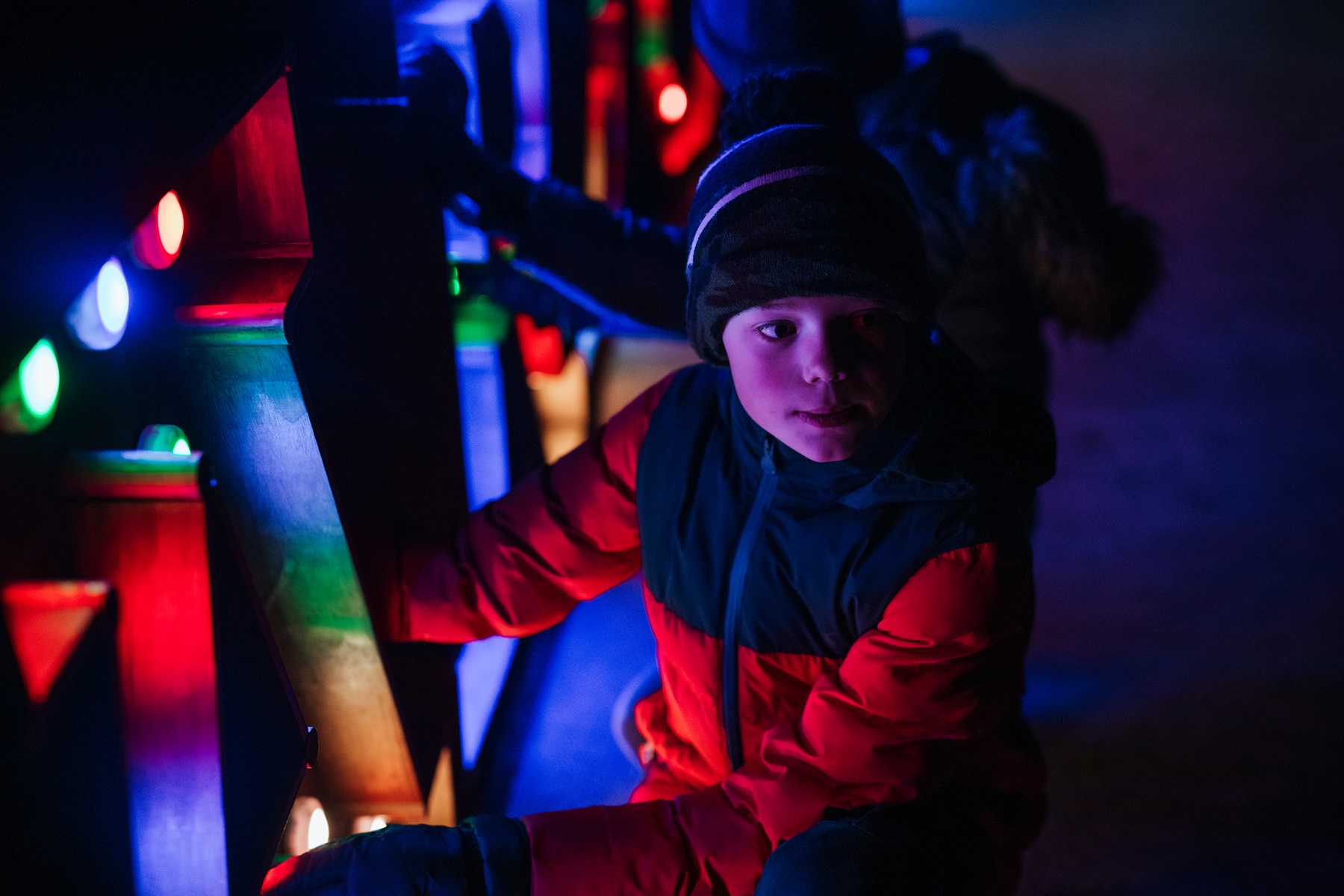 Child interacting with a display at Illuminated Arboretum