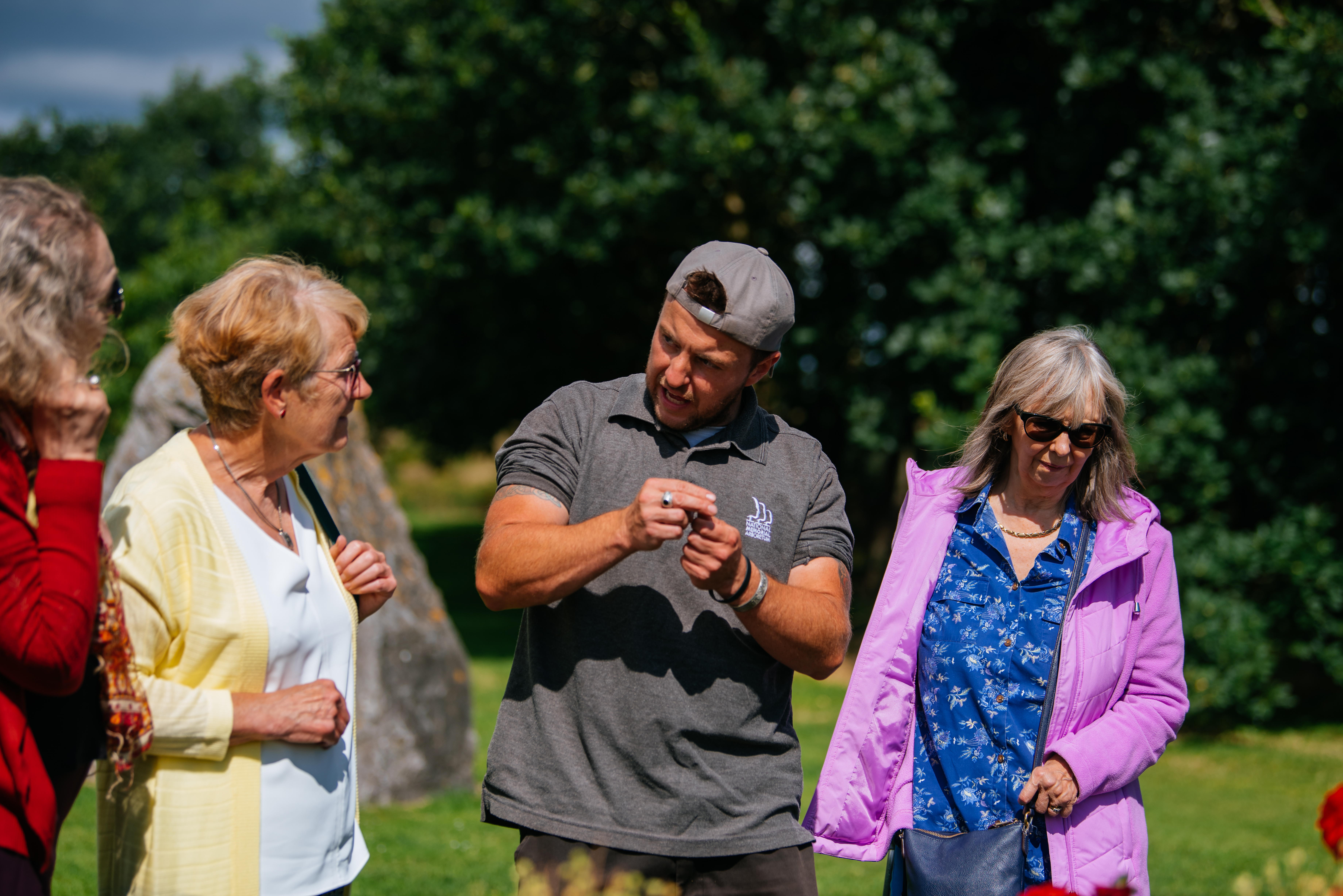 An arboretum team member showing visitors the different plants in one of the green gardens.