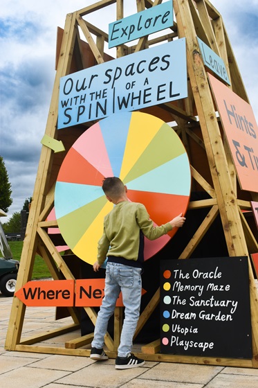 Image of young boy spinning large colourful wheel at the oracle New World installation