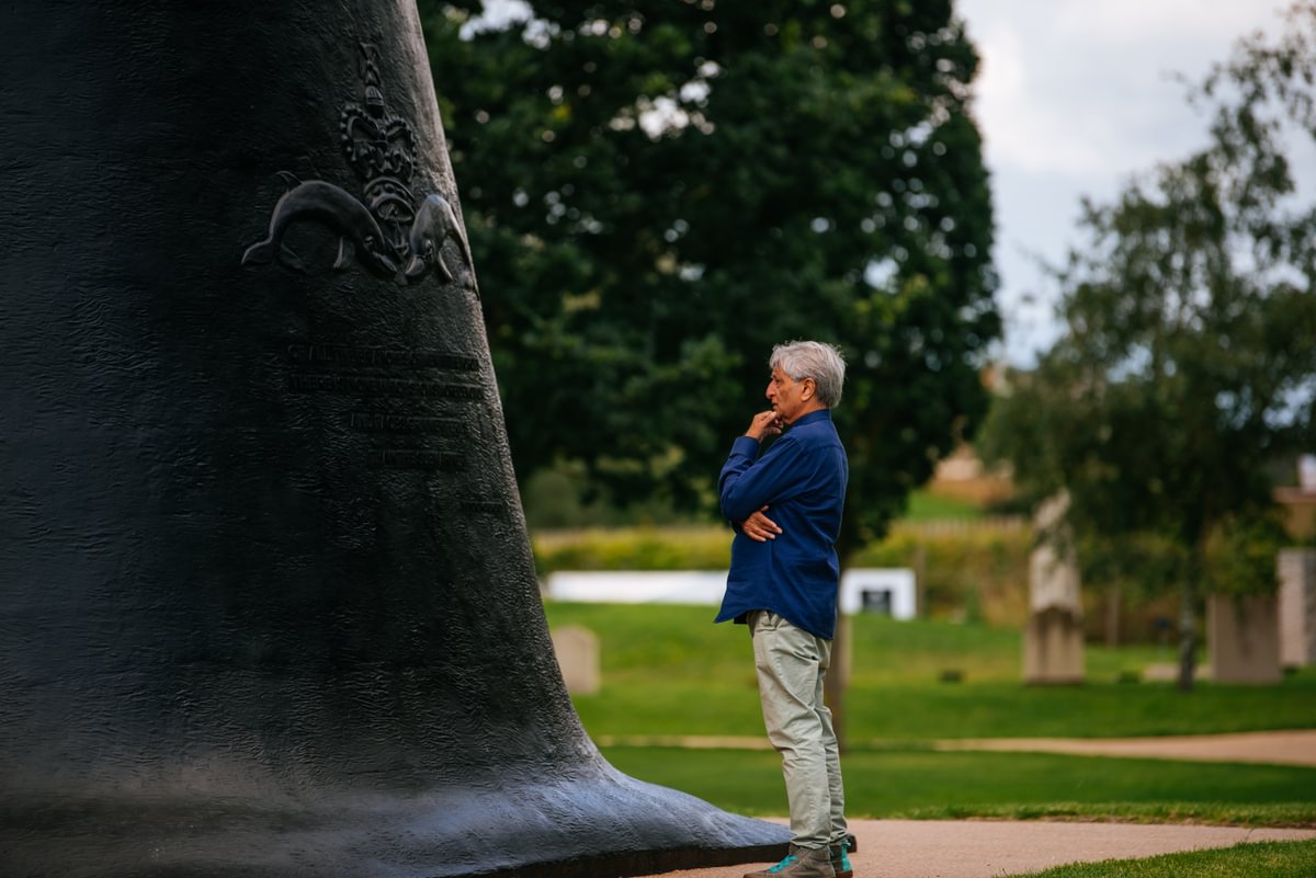 A man looks at the inscription on the side of the Submariners Memorial.