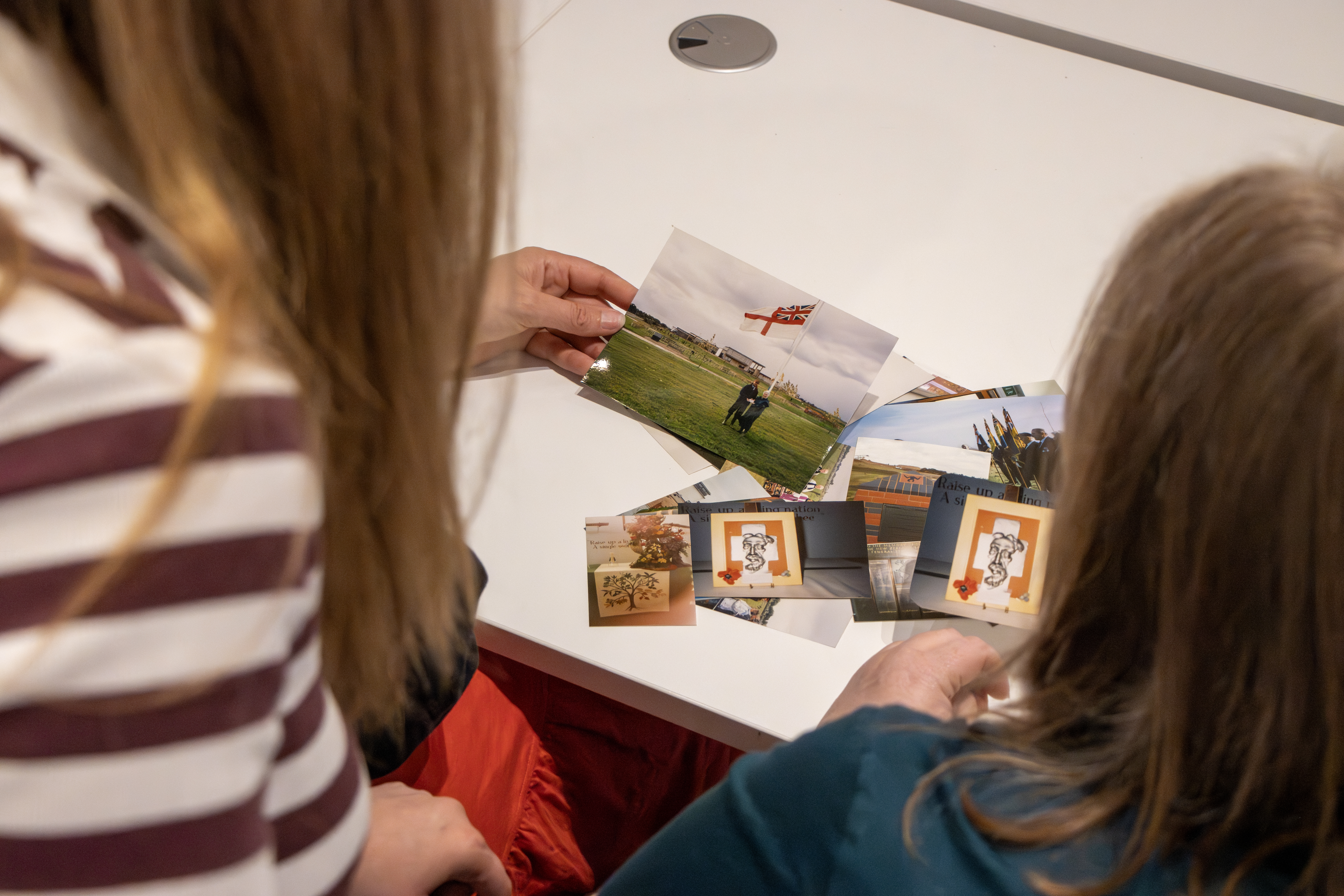Archivists look at old photographs of the Arboretum, including sapling trees and old team photographs.