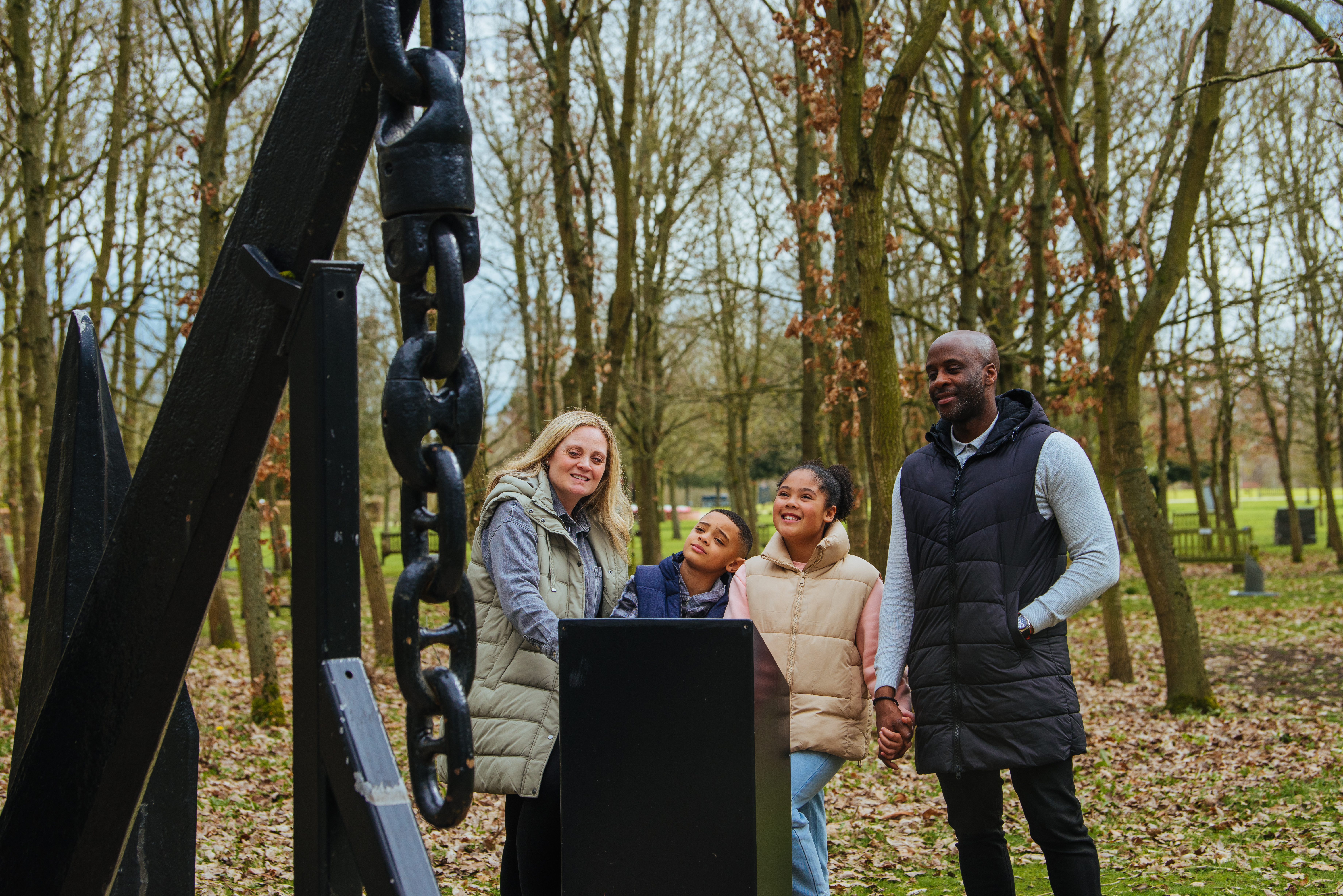 Family exploring the Merchant Navy Wood during the autumn, surrounded by fallen leaves